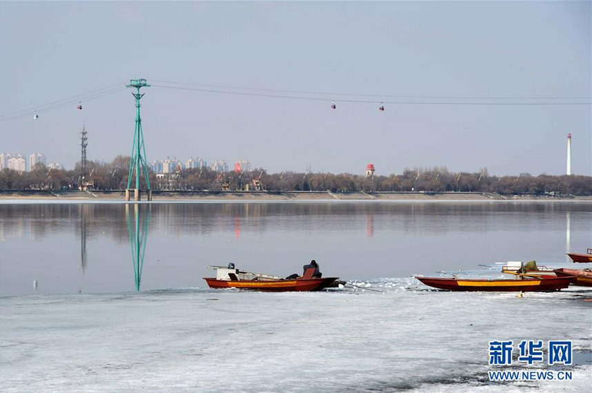 4月1日，渔民在对渔船进行整修。近日，随着气温的升高，松花江哈尔滨段江面逐渐开化。 新华社记者 王凯 摄