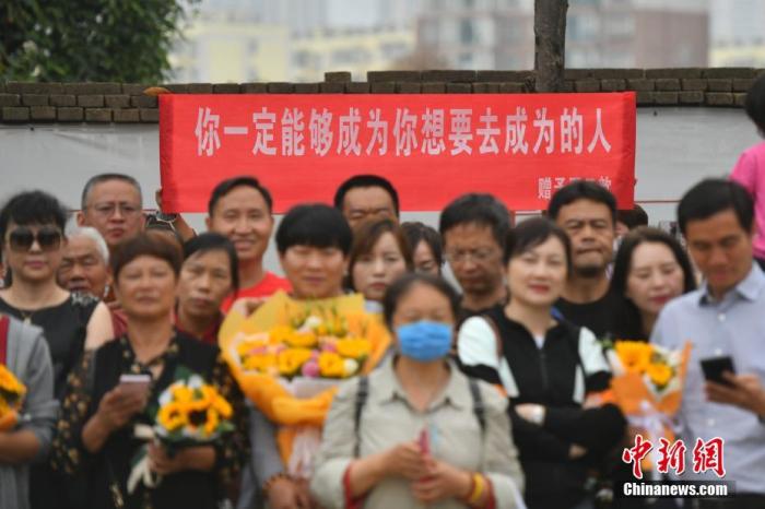 资料图：6月8日，云南省昆明市的考生结束2021年全国高考。图为考试结束后，一幅助考标语前有考生和家长合影留念。 <a target='_blank'  data-cke-saved-href='http://www.chinanews.com/' href='http://www.chinanews.com/'><p  align=